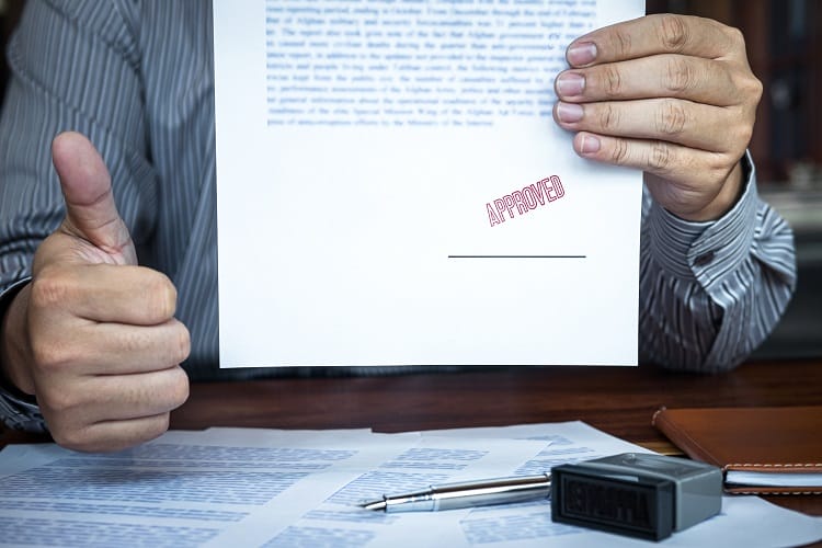 Hands of businessman stamp on paper document to approve heat pump agreement