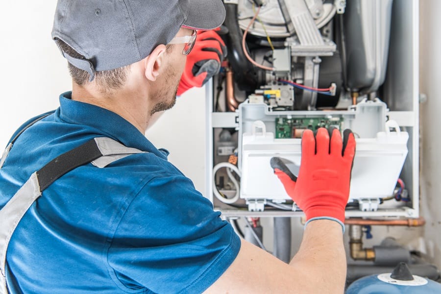 Technician with central gas furnace system Technician with central gas furnace system