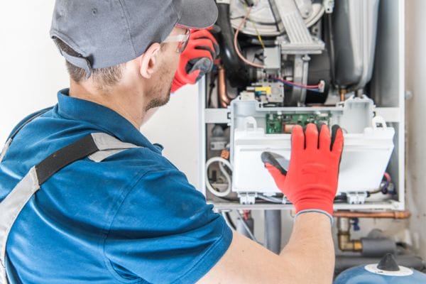 a man working on a gas central heating boiler a man working on a gas central heating boiler