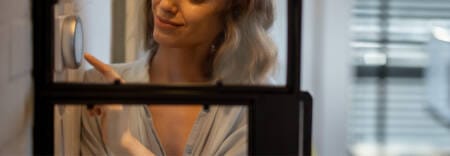 woman adjusting digital thermostat in home