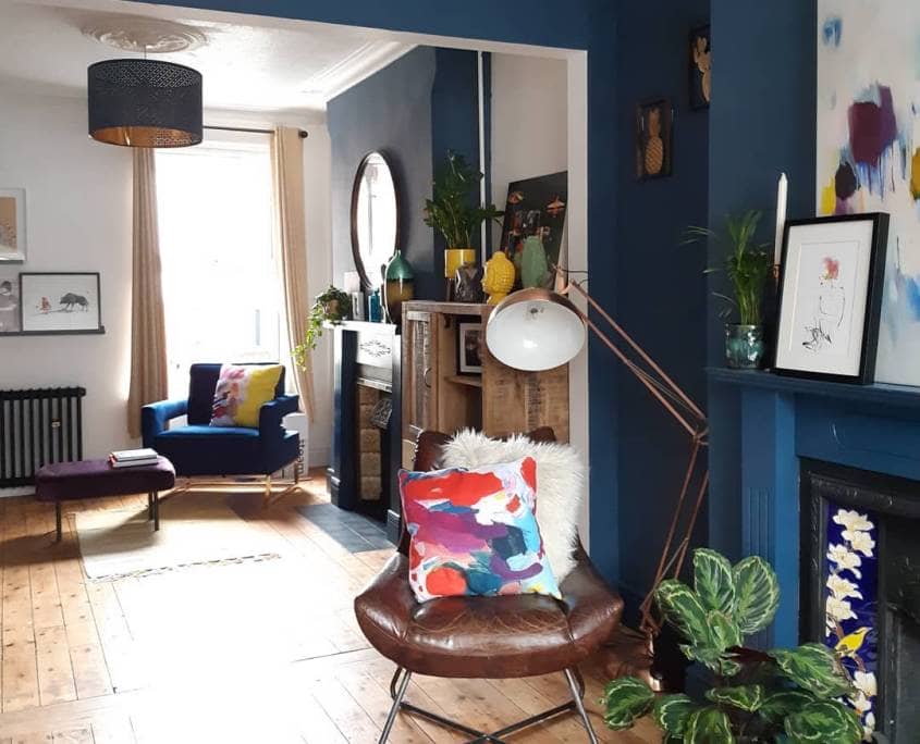 A colourful living room with wooden flooring and a cast-iron radiator.