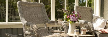 A sad pug wrapped in a blanket trying to keep a conservatory warm and cosy
