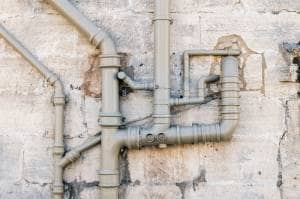 Galvanized steel pipework Galvanized steel heating pipes on dilapidated exterior wall