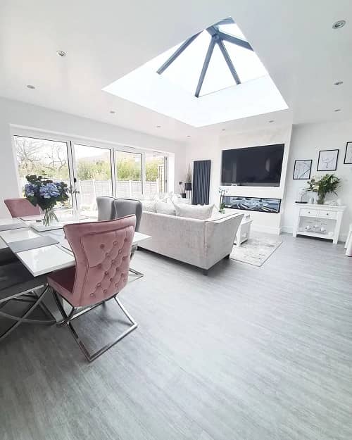 an open plan living space filled with furniture with a vertical radiator in the corner of the room