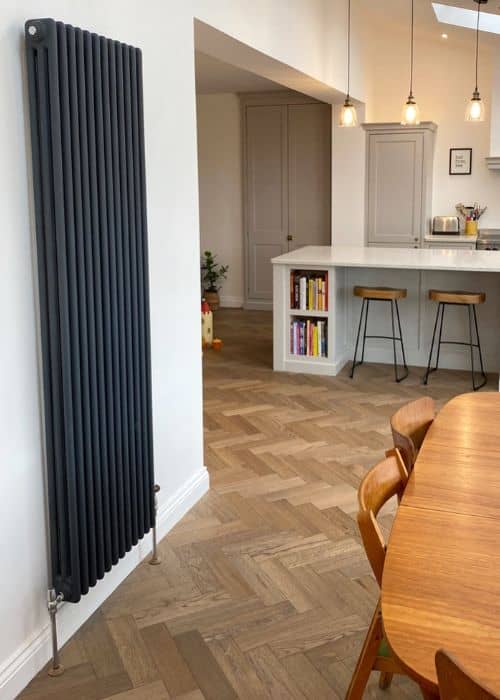 vertical anthracite column radiator in a white kitchen