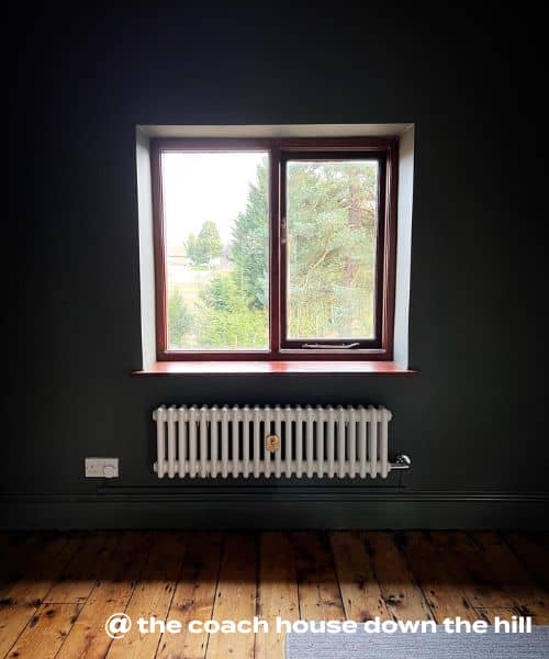 white electric low radiator on a green wall