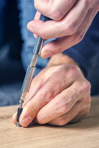 Man assembling furniture at home, hand with screwdriver Man assembling furniture at home, hand with screwdriver