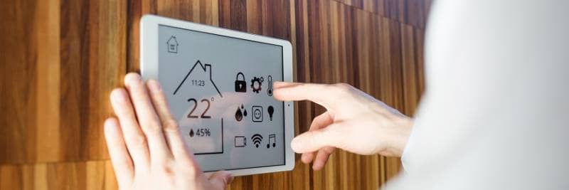 man controls smart home devices using digital tablet with launched application on background of wall. concept of digitalization. climate control system.