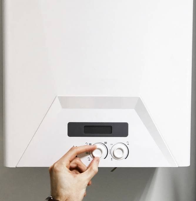 Adjusting boiler dials Close up of left hand turning dials on white central heating boiler system