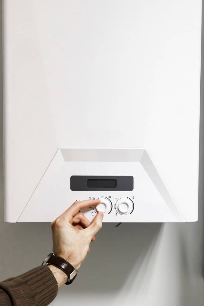 White central heating boiler with dials Close up of left hand adjusting dials on a central heating boiler