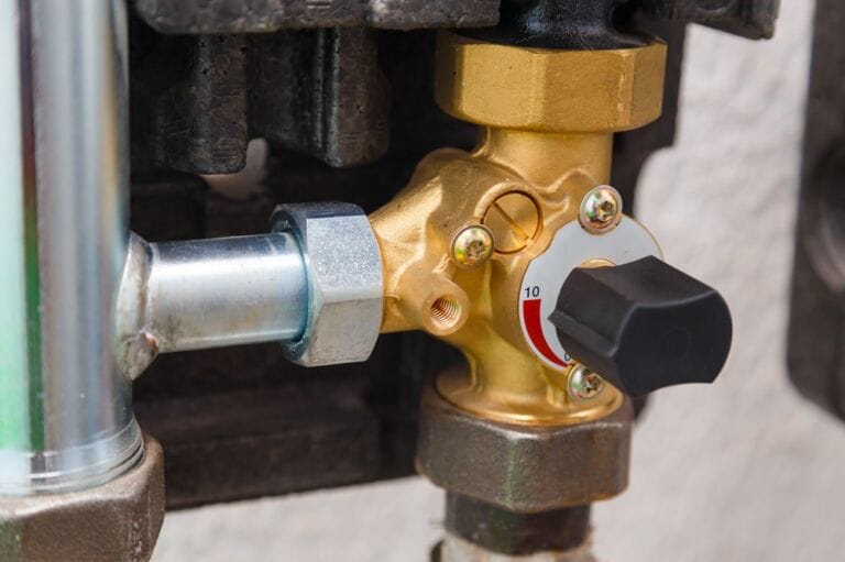 Manual three way ball valve in gold colour on industrial boiler system