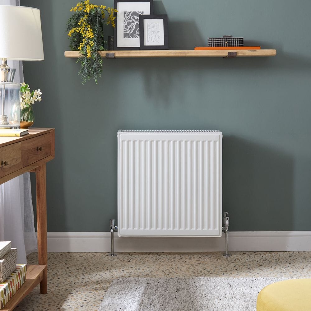 Milano Compact Type 33 white vertical triple panel convector radiator on green wall underneath shelf