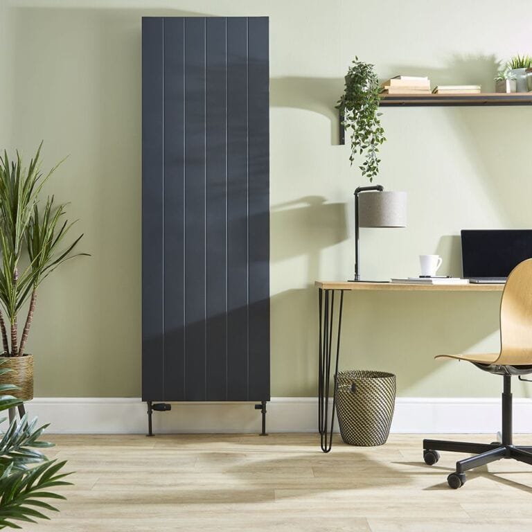 Milano Alora anthracite vertical flat panel type 20 convector radiator on green wall nearby houseplants and shelving