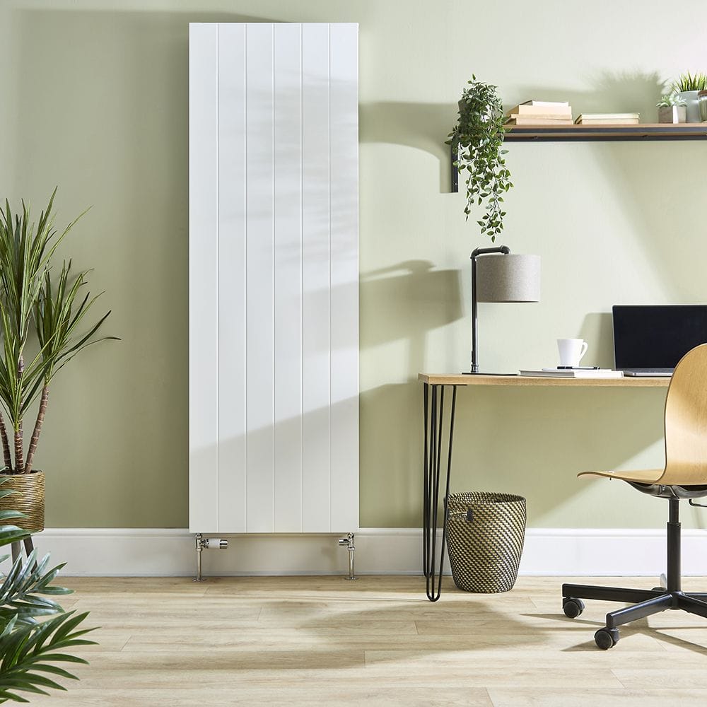 Milano Alora white vertical flat panel type 20 convector radiator on light green background nearby desk with plants and shelving