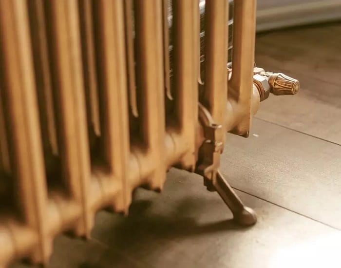 Lower part of gold cast iron radiator Close up shot of foot of gold cast iron radiator