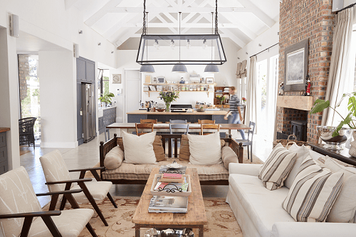 open-plan-interior-of-a-modern-period-conversion-TERY6PX a long kitchen/diner/loung space with a feature fireplace being used instead of a kitchen radiator