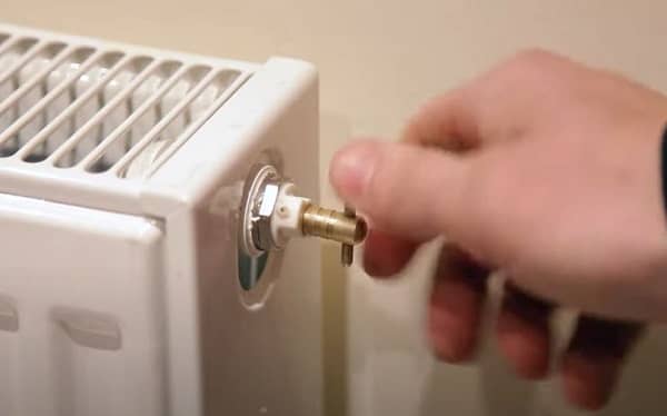 a bleed valve being opened on a radiator