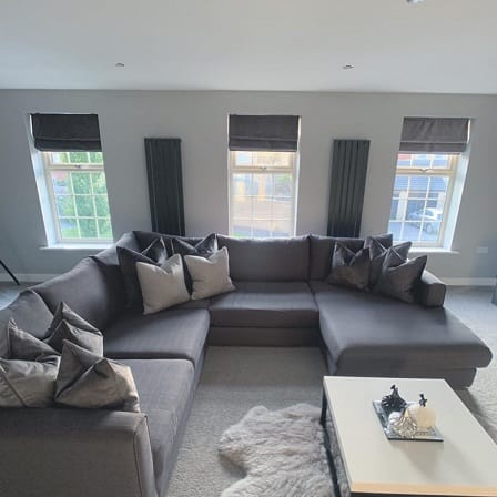 2 vertical radiators side by side between windows in a living room 2 vertical radiators side by side between windows in a living room