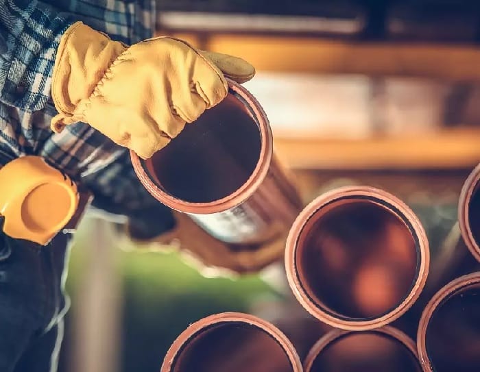Buying Sanitary Plastic Pipes Plastic pipes handled by handyman with yellow gloves
