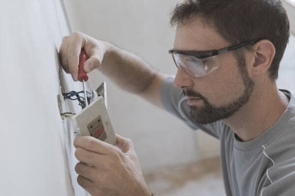 electrician fitting a switch