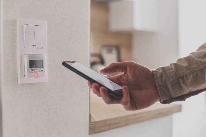 Gold cast iron radiator with pattern Smartphone connecting to home eco heating system