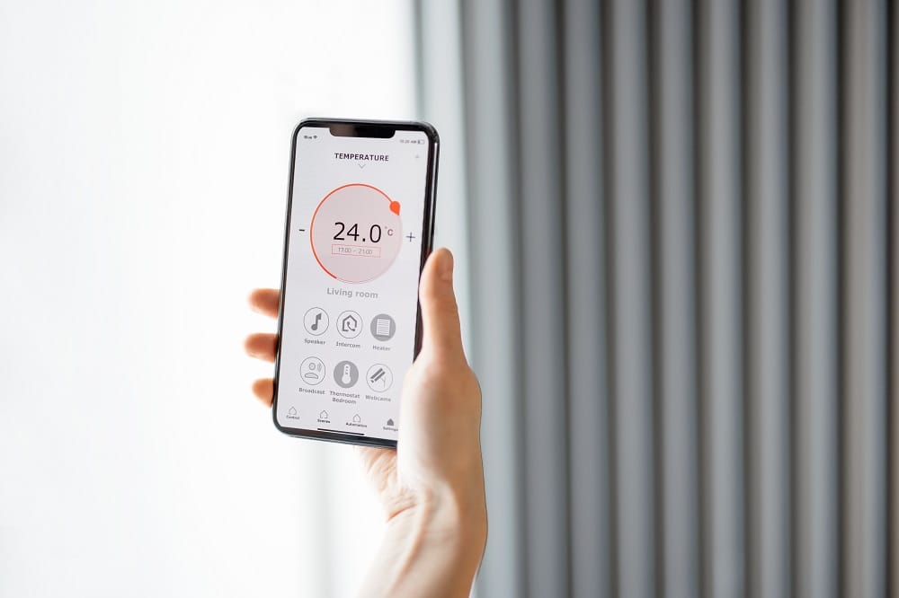 Smartphone temperature adjustment app Hand holding smartphone with app open for temperature adjustment