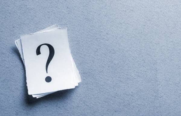 a stack of question marks on some paper on a blue background