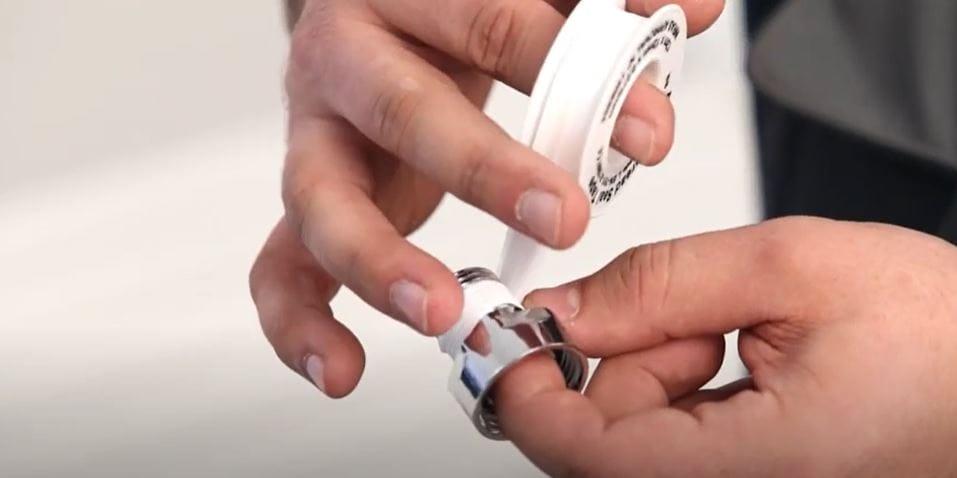 hands wrapping ptfe tape around a radiator valve