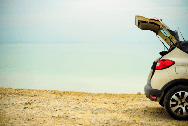 a car with its boot open at the beach