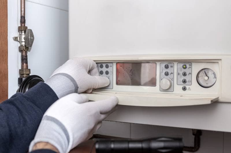 Domestic heating boiler being serviced by technician