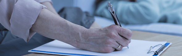 taking notes on a sheet of paper