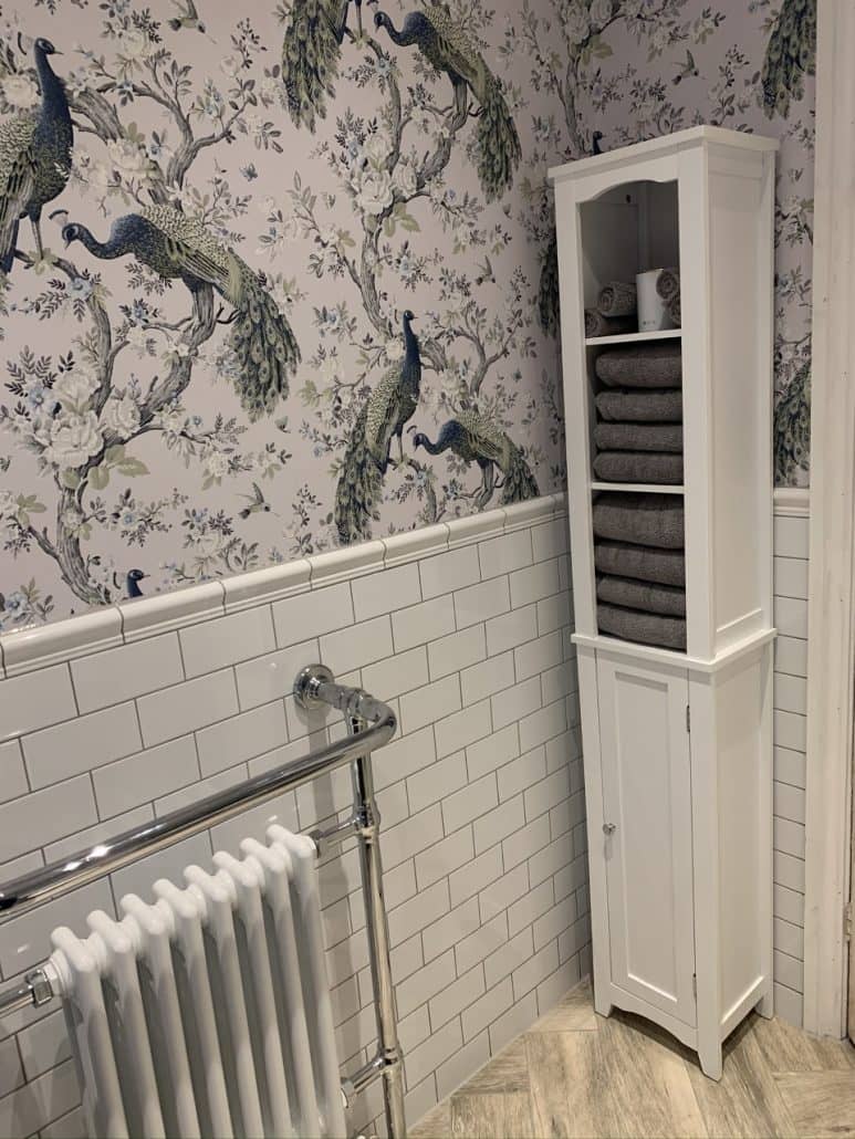 A white towel radiator and a towel rack in a white bathroom