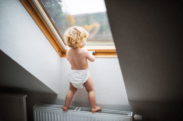 a small child climbing on a radiator a small child climbing on a radiator