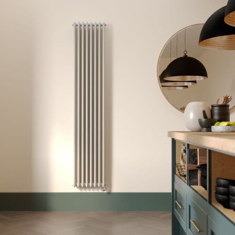 Milano Windsor white traditional vertical electric triple column radiator on light wall nearby large mirror and modern countertop