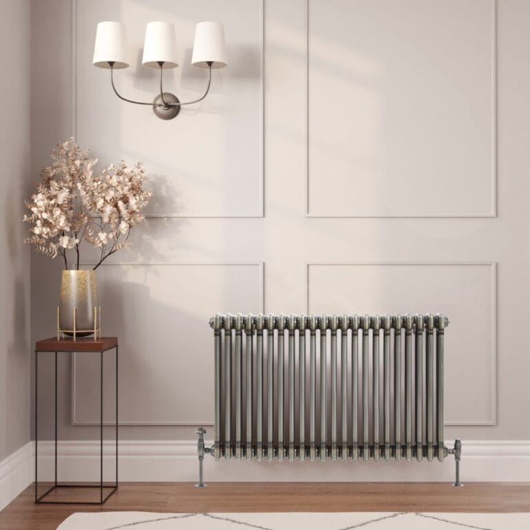 Milano Windsor lacquered raw metal traditional horizontal triple column radiator on light wall nearby table with gold vase beneath triple light fitting