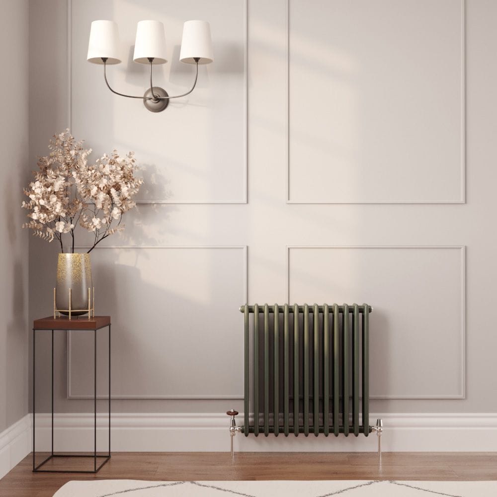 Milano Windsor green horizontal traditional double column radiator on light wall nearby triple light fitting and table with gold vase