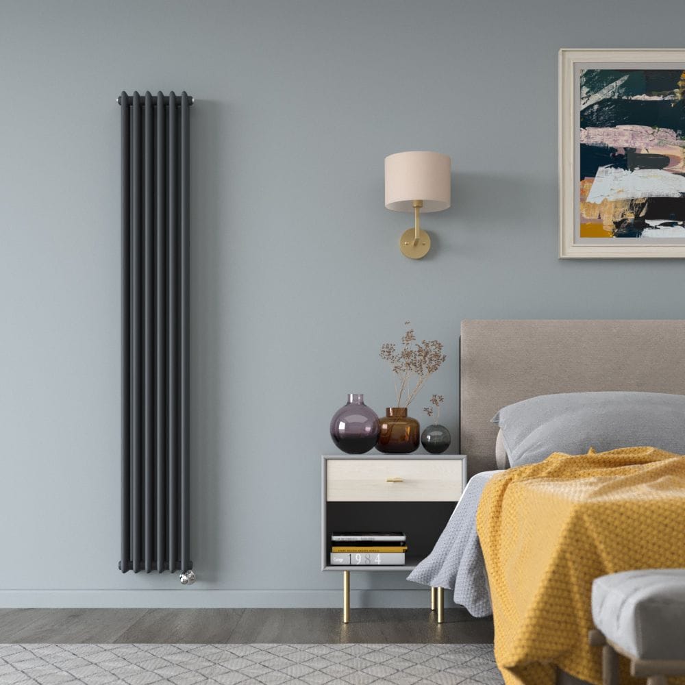 Milano Windsor anthracite traditional vertical electric triple column radiator on light blue wall nearby bedside table and bed beneath artwork and light fitting