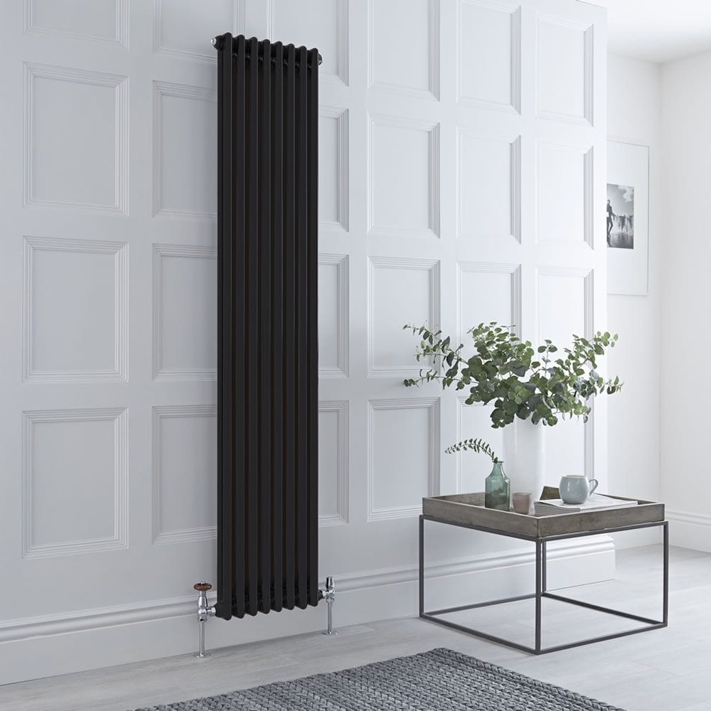 Milano Windsor black traditional vertical double column radiator on white wall nearby table with white vase and houseplant