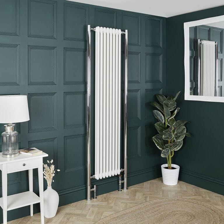 Milano Windsor white vertical traditional double column radiator on green wall nearby houseplant and mirror and white dressing table with white lamp on top