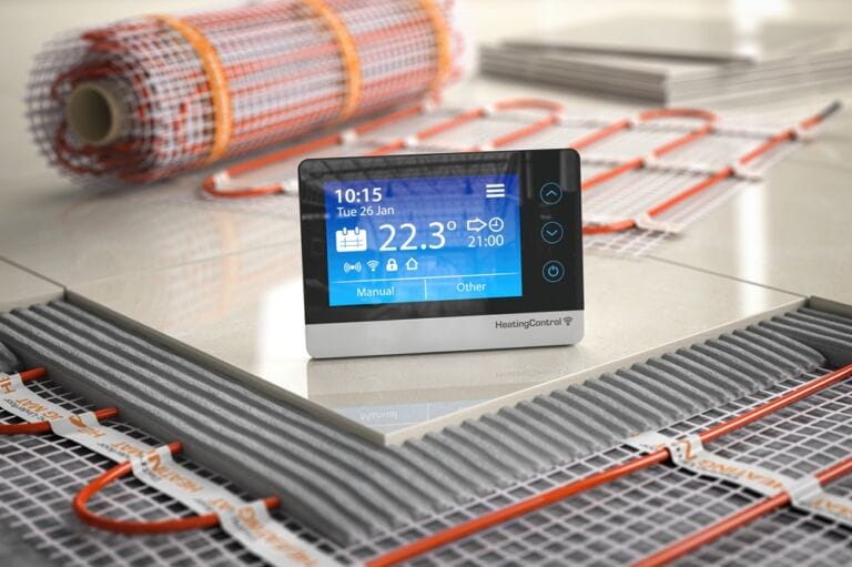 Digital thermostat on tile above electric underfloor heating network wiring