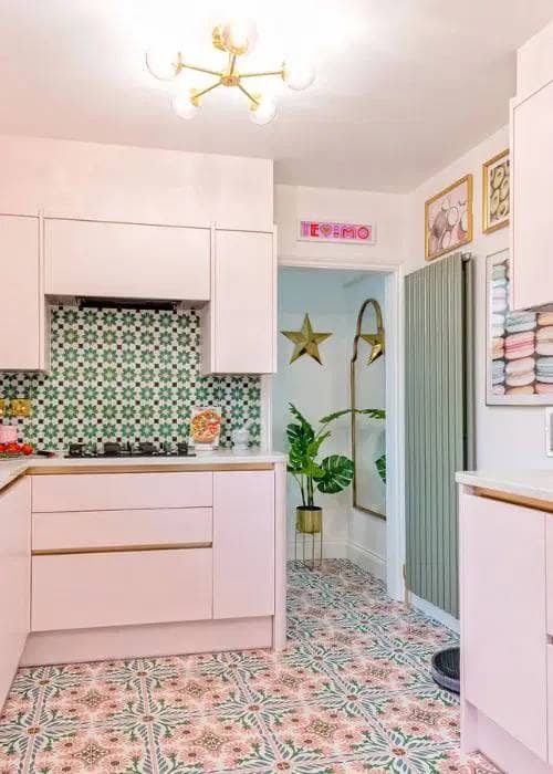a green vertical radiator in a pink kitchen space - showing how versatile a vertical radiator can be