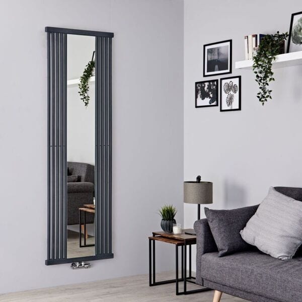 Terma Intra stone mirrored vertical designer radiator on light wall in modern interior nearby small table with houseplant and grey settee with grey cushions