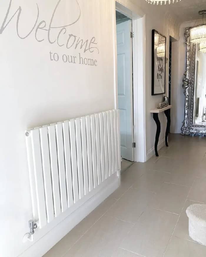 A white Milano Alpha designer radiator from BestHeating on a white wall.