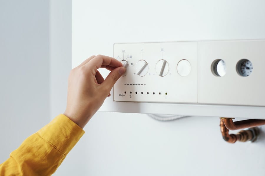 Woman adjusting boiler settings Woman adjusting boiler settings