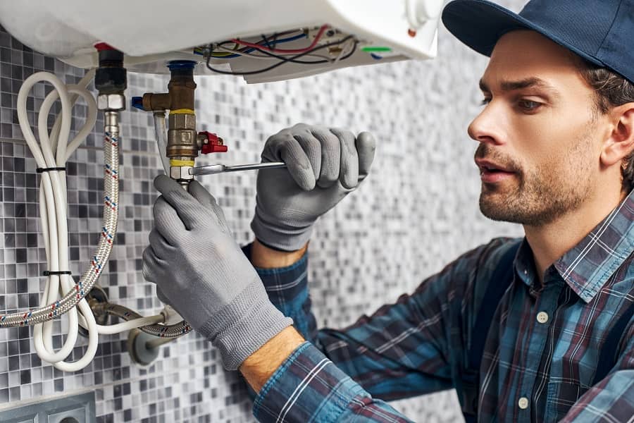 Technician using spanner to set up electric heating system