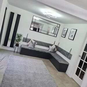 customer submitted image of vertical mirrored radiator installed on wall in spacious living room