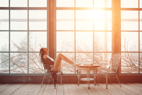 cute woman sitting in a woindow in a conservatory